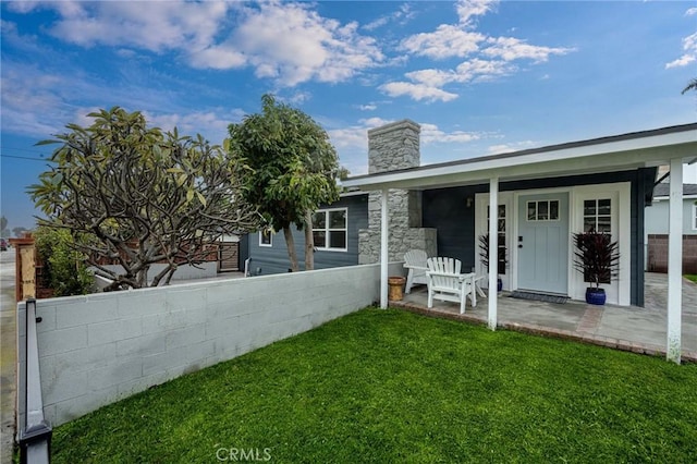 rear view of house featuring a lawn