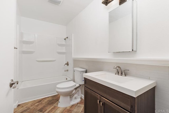 full bathroom with toilet, tile walls, wood-type flooring, shower / bathtub combination, and vanity