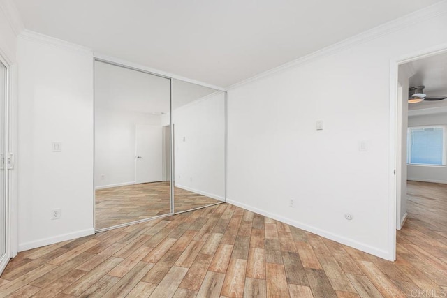 unfurnished bedroom with light wood-type flooring, a closet, and ornamental molding