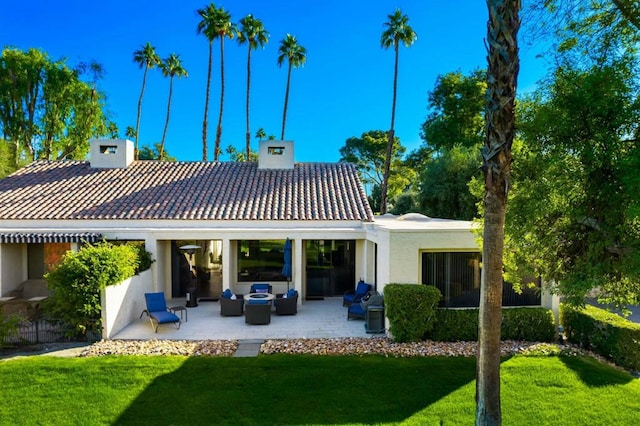 rear view of property featuring an outdoor hangout area, a lawn, and a patio