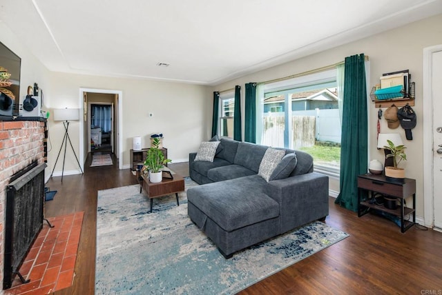 living room with dark wood-type flooring and a fireplace