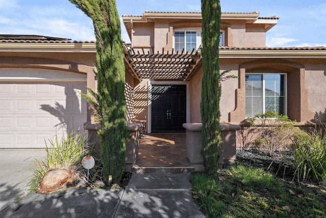 property entrance with a pergola and a garage