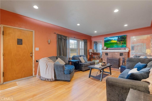 living room with light wood-type flooring and a fireplace