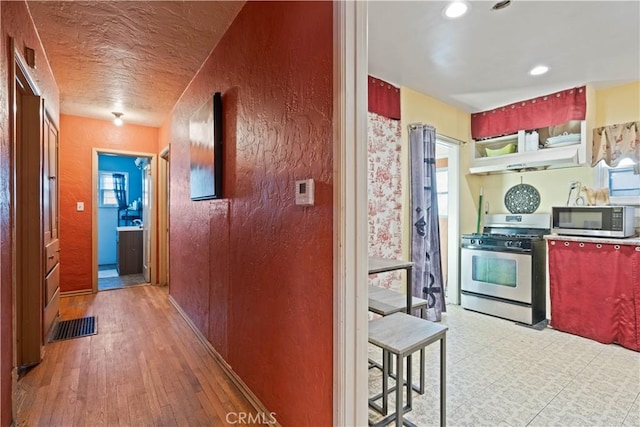 kitchen featuring hardwood / wood-style flooring, plenty of natural light, and appliances with stainless steel finishes