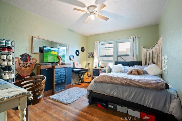 bedroom featuring ceiling fan, a textured ceiling, and hardwood / wood-style floors