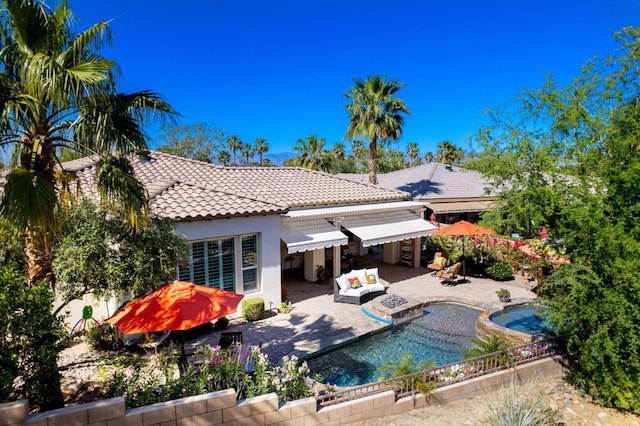 back of house featuring a pool with hot tub, a patio area, and outdoor lounge area