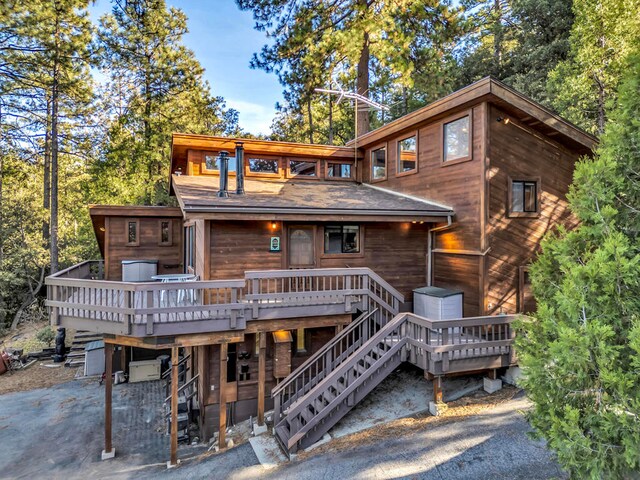 back of property with a wooden deck and a patio area