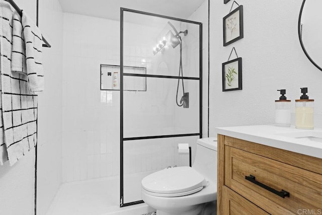 bathroom with toilet, a shower with door, and vanity