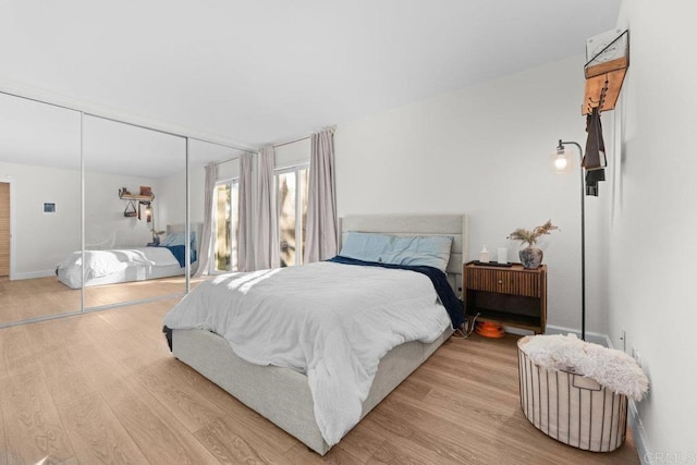 bedroom with light hardwood / wood-style floors and a closet