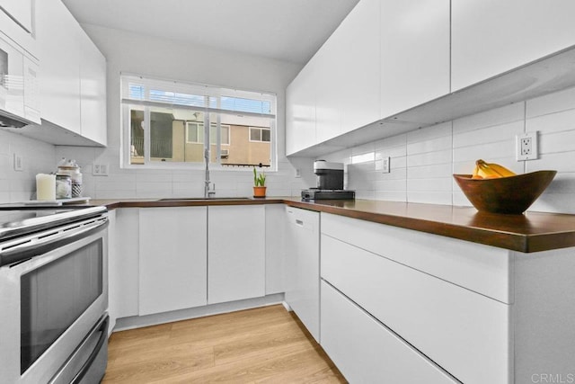 kitchen with white appliances, white cabinetry, light hardwood / wood-style floors, sink, and backsplash