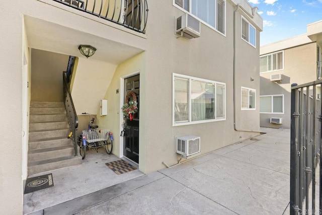 6602 Beadnell Way Unit 14, San Diego, CA 92117 - doorway to property featuring stucco siding, a patio area, and an AC wall unit