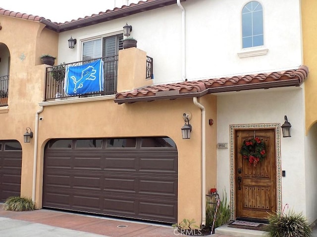 view of front of home with a garage and a balcony