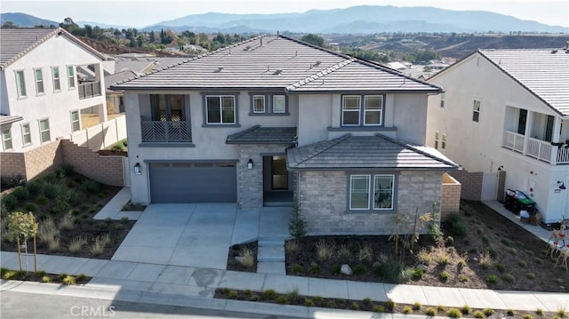 view of front of property with a mountain view, a garage, and a balcony