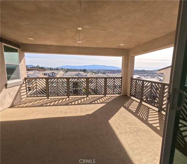 view of patio featuring a mountain view and a balcony