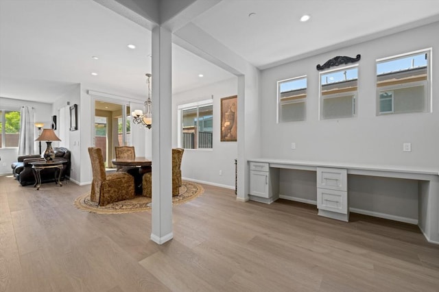 interior space with built in desk, plenty of natural light, and light hardwood / wood-style flooring