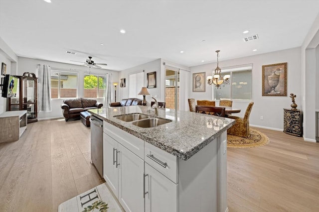 kitchen featuring white cabinets, decorative light fixtures, sink, a kitchen island with sink, and stainless steel dishwasher