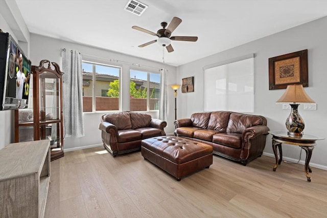 living room with light wood-type flooring and ceiling fan