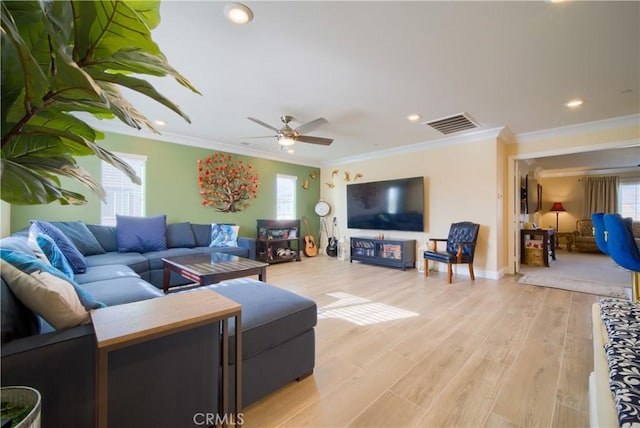 living room featuring ceiling fan, ornamental molding, a healthy amount of sunlight, and light hardwood / wood-style floors