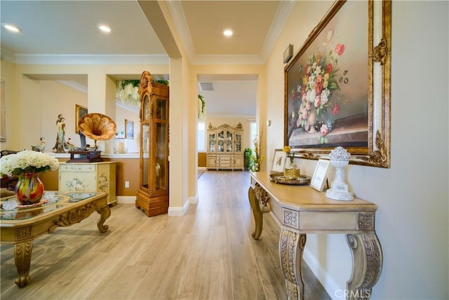 hall featuring ornamental molding and light hardwood / wood-style floors