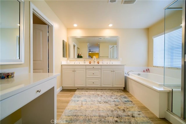 bathroom featuring wood-type flooring, vanity, and separate shower and tub