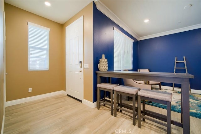 dining room with crown molding and light wood-type flooring