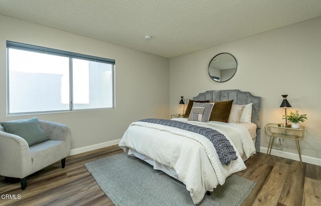 bedroom with dark wood-type flooring and a textured ceiling