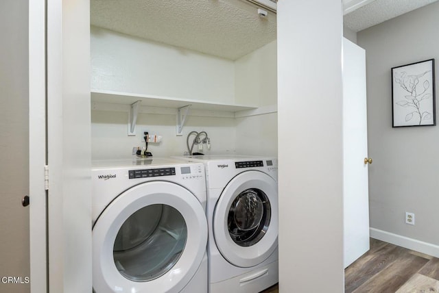 washroom featuring a textured ceiling, dark hardwood / wood-style flooring, and washing machine and clothes dryer