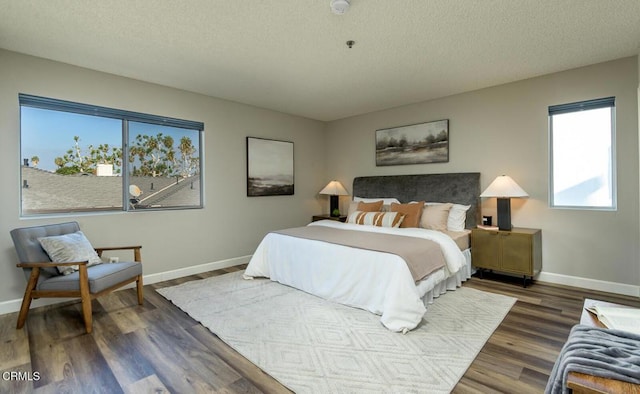 bedroom featuring a textured ceiling and dark hardwood / wood-style flooring