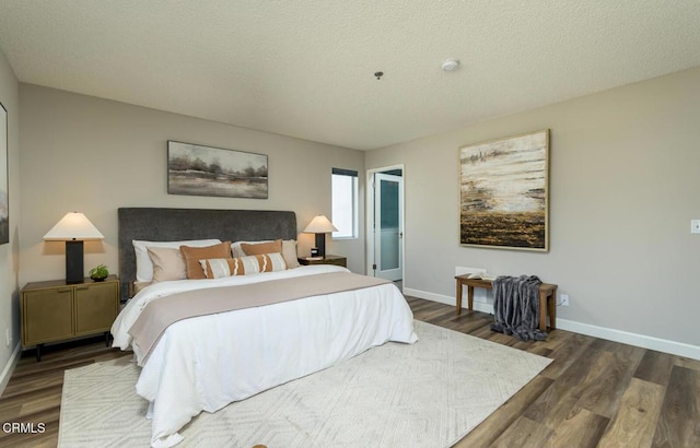 bedroom with dark hardwood / wood-style floors and a textured ceiling