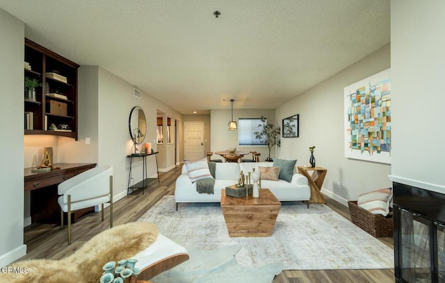 living room with a textured ceiling and hardwood / wood-style flooring