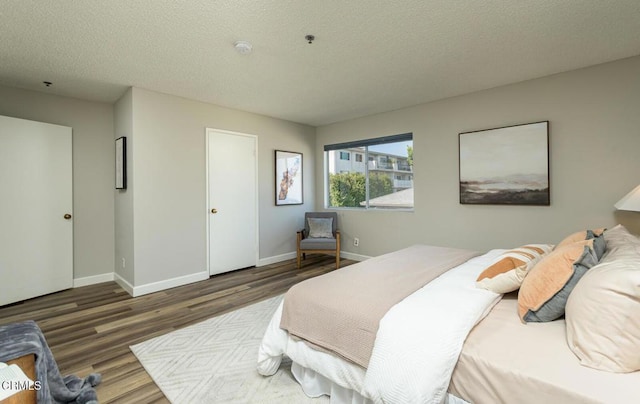 bedroom featuring a textured ceiling and dark hardwood / wood-style floors