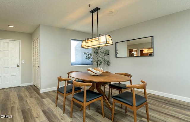 dining area with a textured ceiling and hardwood / wood-style floors