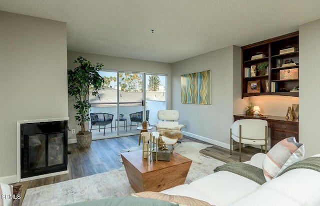 living room featuring wood-type flooring and a textured ceiling