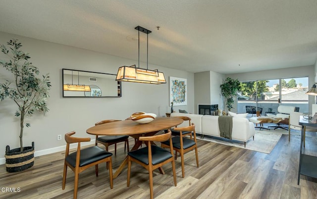 dining area with hardwood / wood-style floors and a textured ceiling