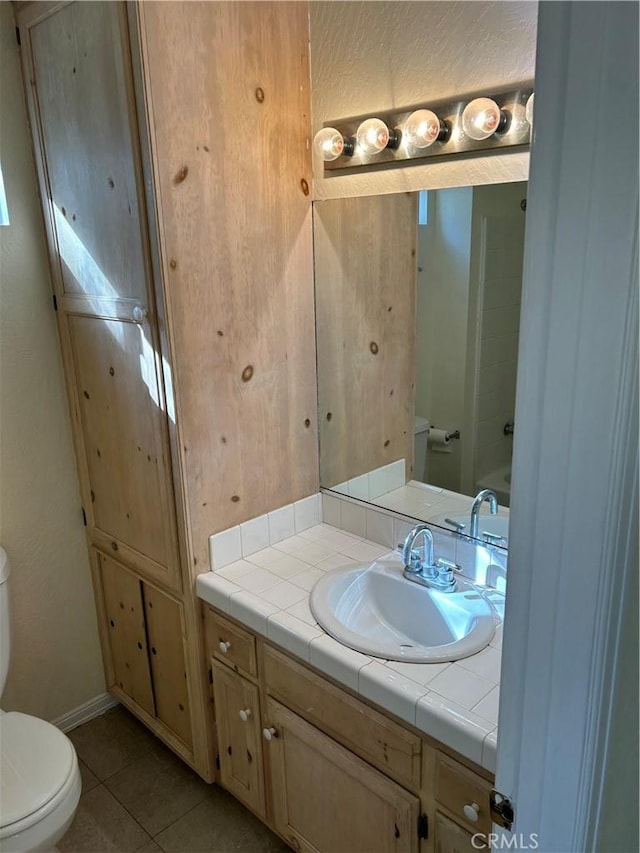 bathroom with toilet, tile patterned floors, and vanity