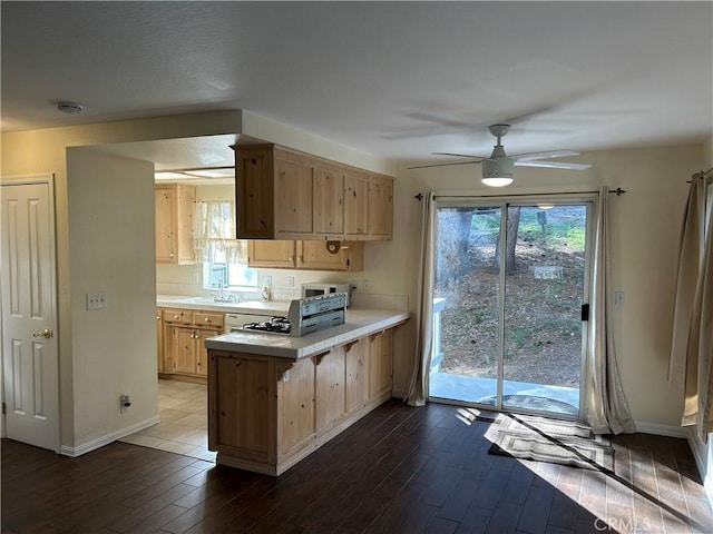 kitchen featuring ceiling fan, kitchen peninsula, sink, dark wood-type flooring, and light brown cabinets