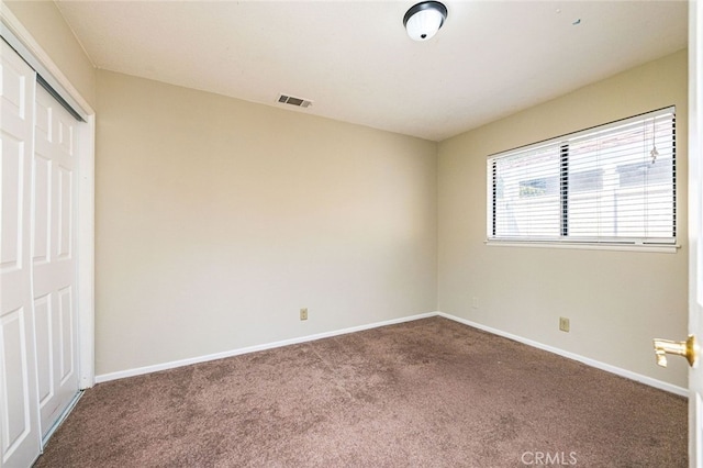 unfurnished bedroom with a closet and carpet flooring