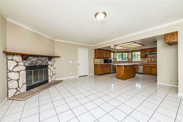 kitchen featuring a kitchen island, decorative backsplash, stainless steel dishwasher, and a stone fireplace