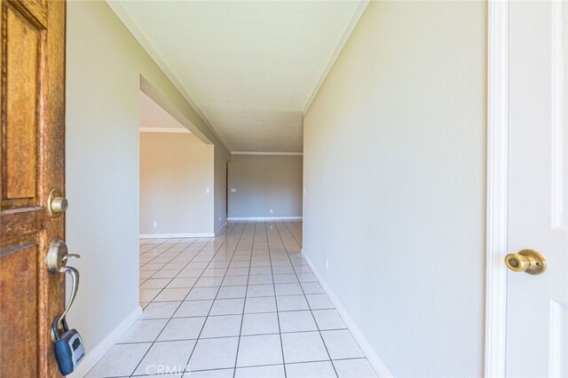 corridor featuring ornamental molding and light tile patterned flooring