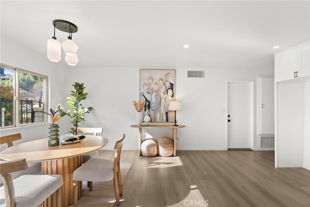 dining room with wood-type flooring and a chandelier