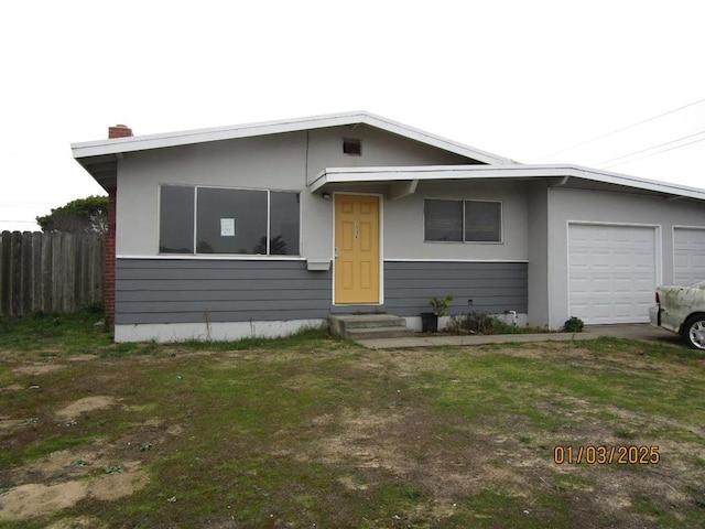 view of front of home with a front yard and a garage