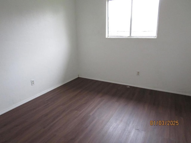 unfurnished room with dark wood-type flooring