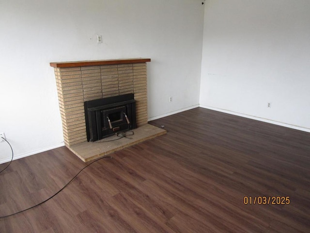 unfurnished living room featuring dark wood-type flooring and a fireplace