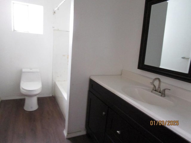 full bathroom featuring toilet, wood-type flooring, vanity, and bathtub / shower combination