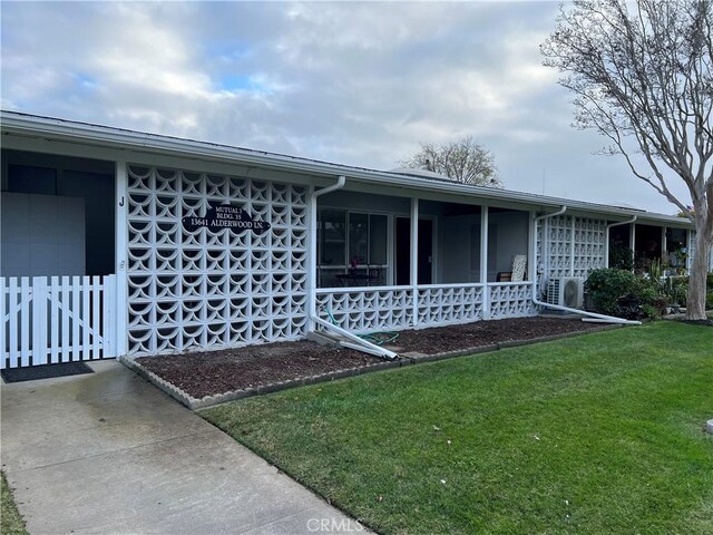 view of front of house featuring ac unit and a front lawn