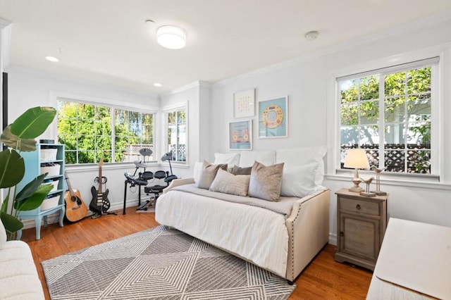 bedroom with ornamental molding and light hardwood / wood-style flooring