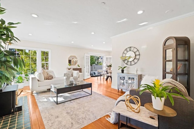 living room with hardwood / wood-style flooring and crown molding