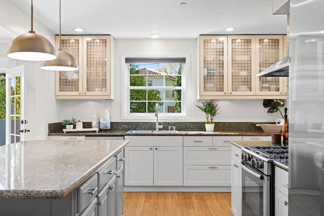 kitchen with pendant lighting, sink, dark stone countertops, white cabinets, and stainless steel appliances