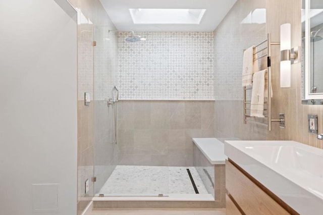 bathroom with walk in shower, vanity, and a skylight