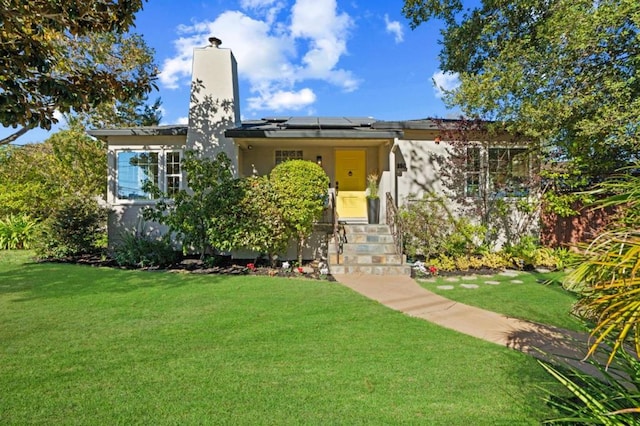 view of front facade with a front yard and solar panels